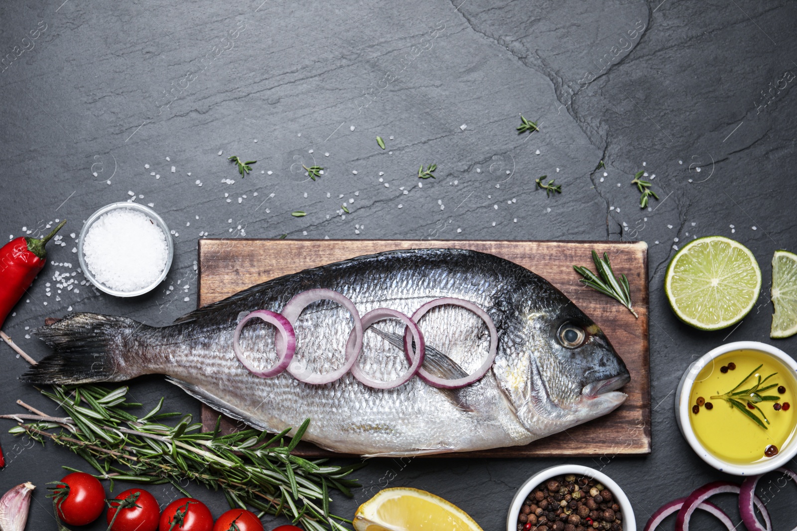 Photo of Flat lay composition with fresh raw dorado fish and ingredients on black table, space for text