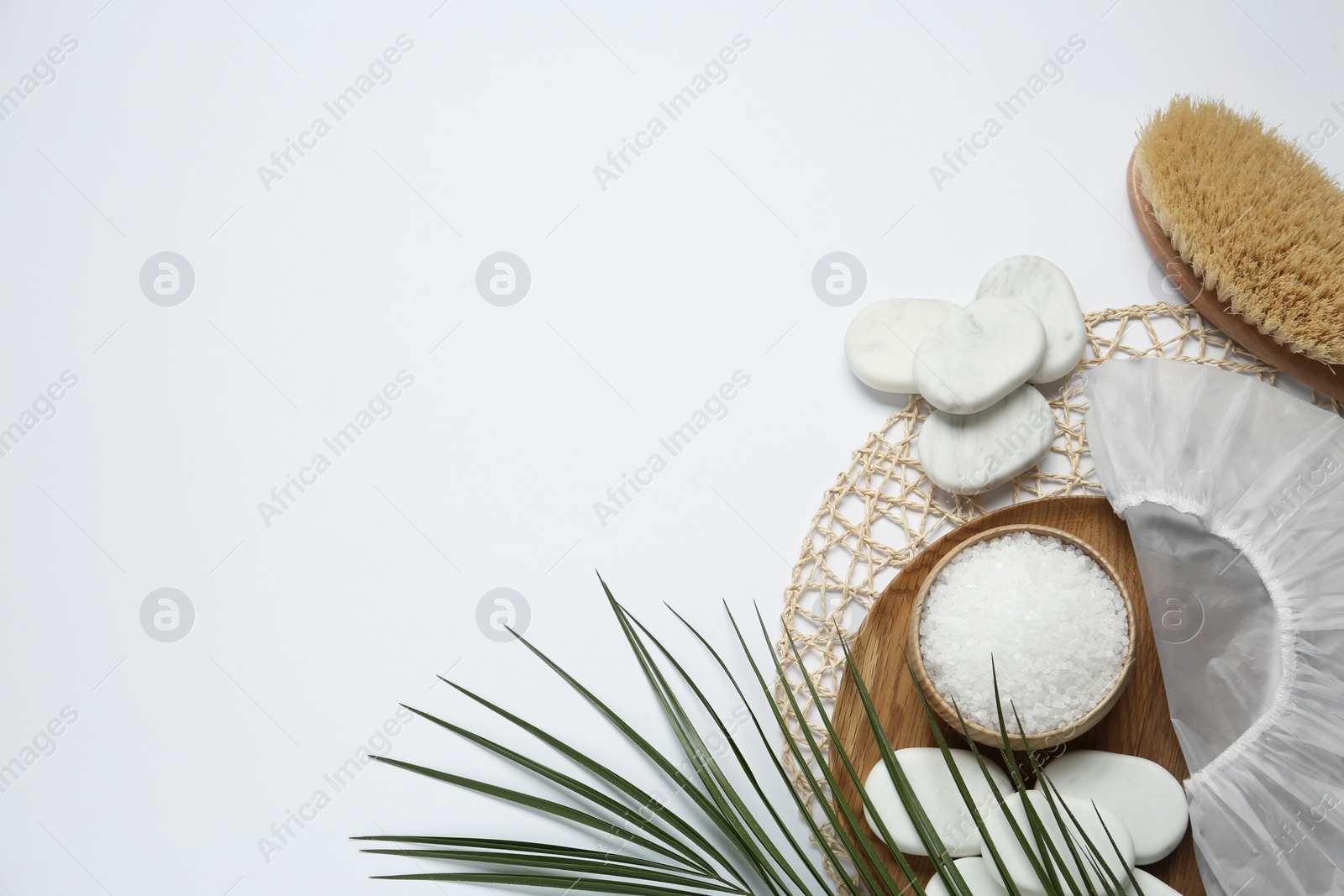 Photo of Flat lay composition with shower cap and spa stones on white background. Space for text