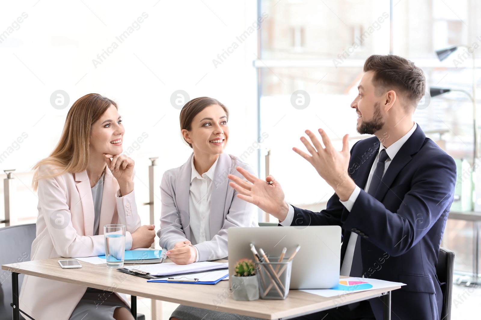 Photo of Young consultant working with clients in office