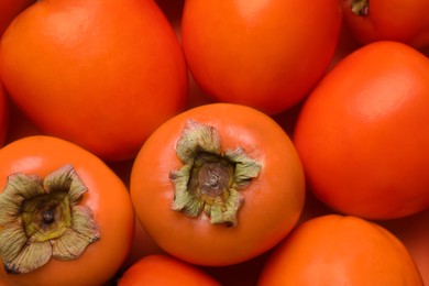 Photo of Delicious ripe juicy persimmons as background, closeup