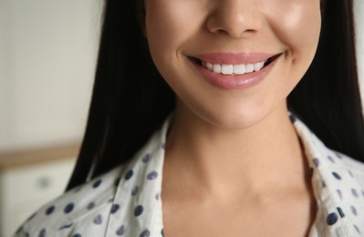 Photo of Young woman with healthy teeth on blurred background, closeup