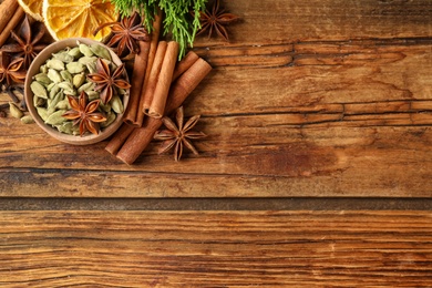 Photo of Flat lay composition with mulled wine ingredients on wooden table. Space for text