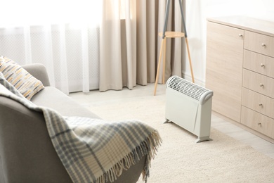 Photo of Modern electric heater in stylish room interior