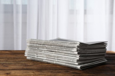 Stack of newspapers on wooden table. Journalist's work