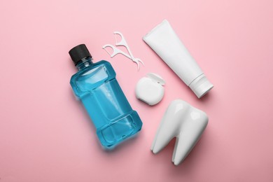 Photo of Flat lay composition with mouthwash and other oral hygiene products on pink background