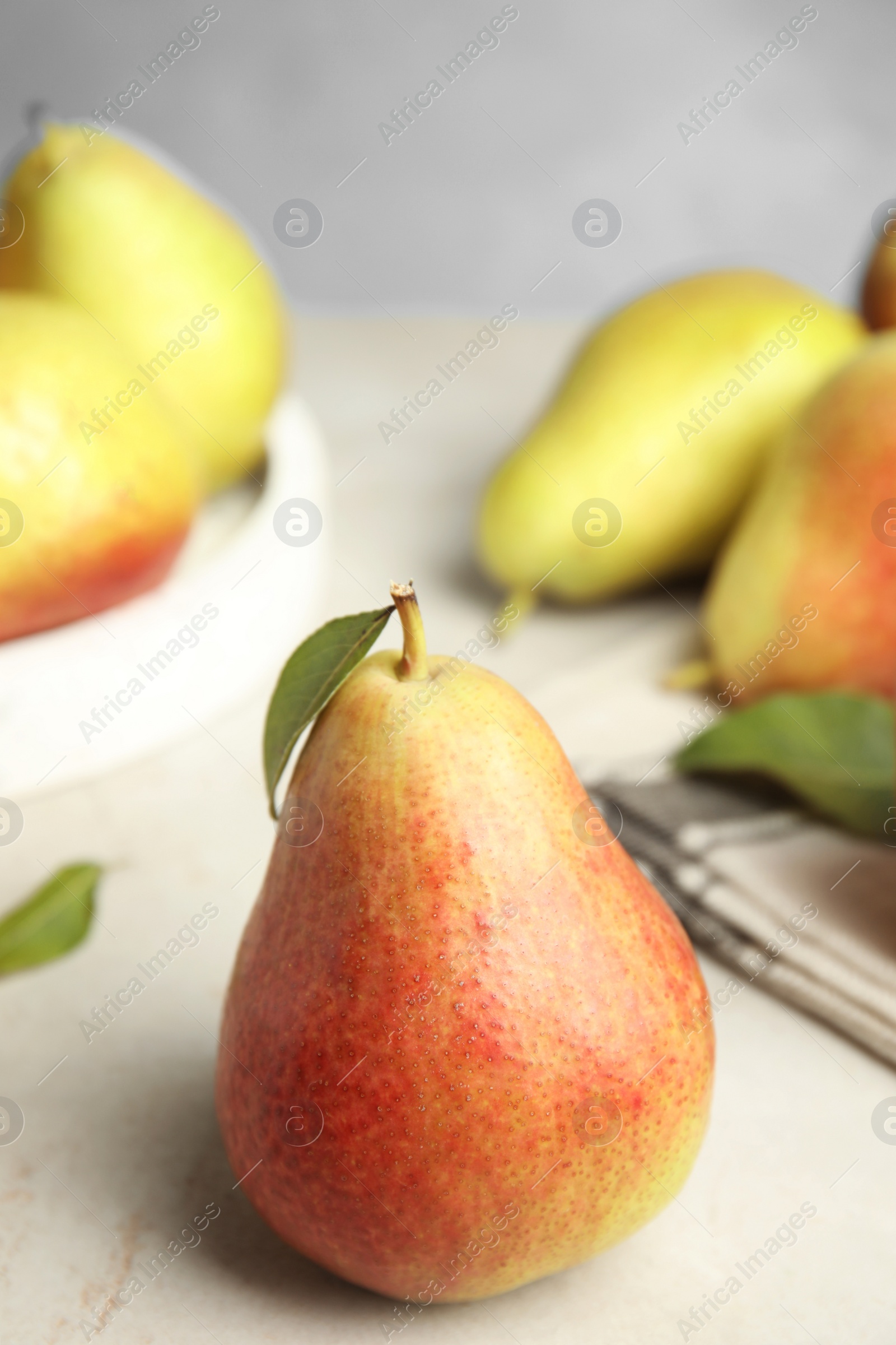 Photo of Ripe juicy pears on white stone table against blue background