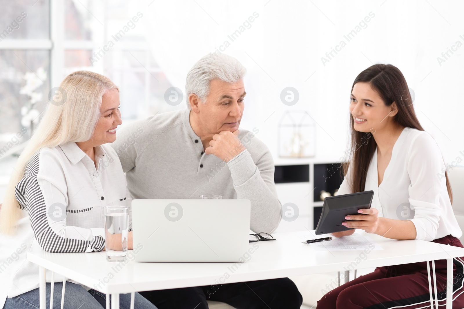 Photo of Mature couple discussing pension with consultant in office