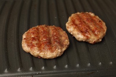 Tasty hamburger patties on grill pan, closeup