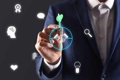 Man aiming with dart to digital handshake icon on dark background, closeup