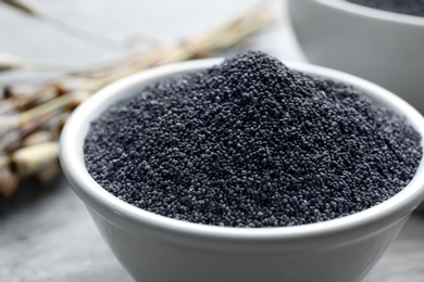 Poppy seeds in bowl on table, closeup