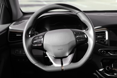 Photo of Black steering wheel and dashboard in modern car