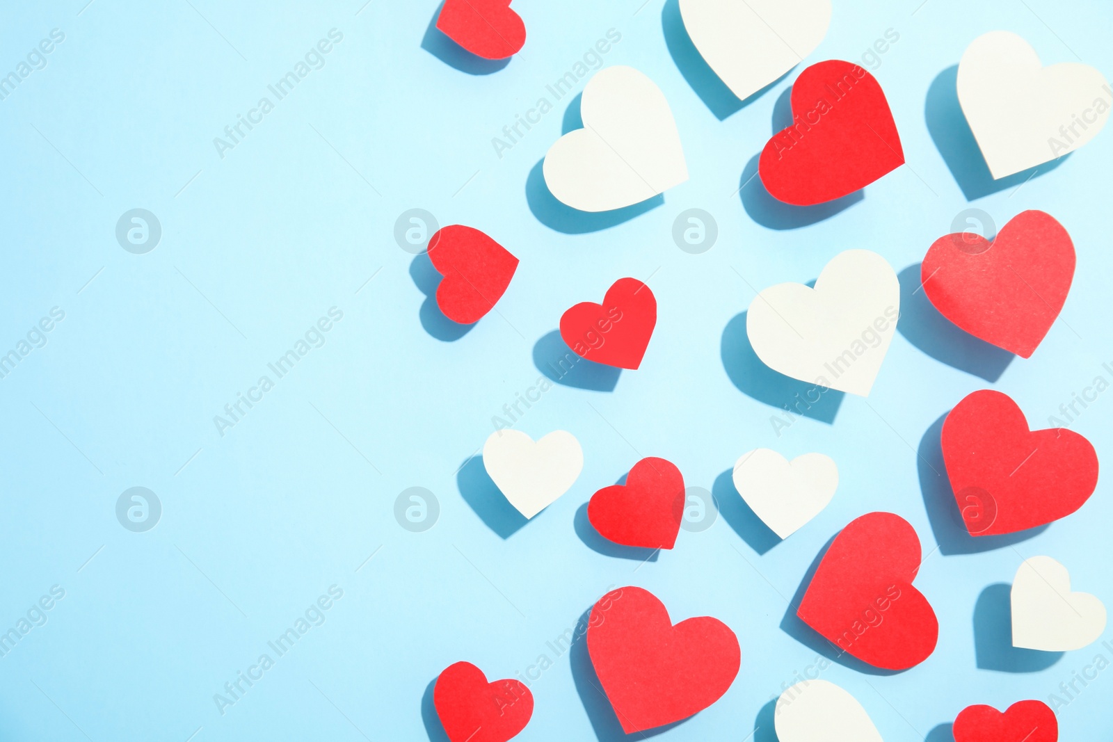 Photo of Small paper hearts on color background, top view