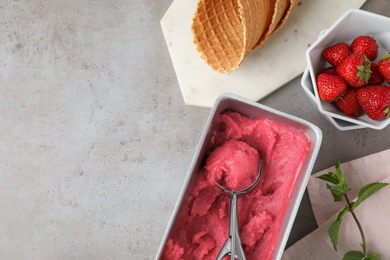 Photo of Flat lay composition with pink ice cream and strawberries on grey table. Space for text