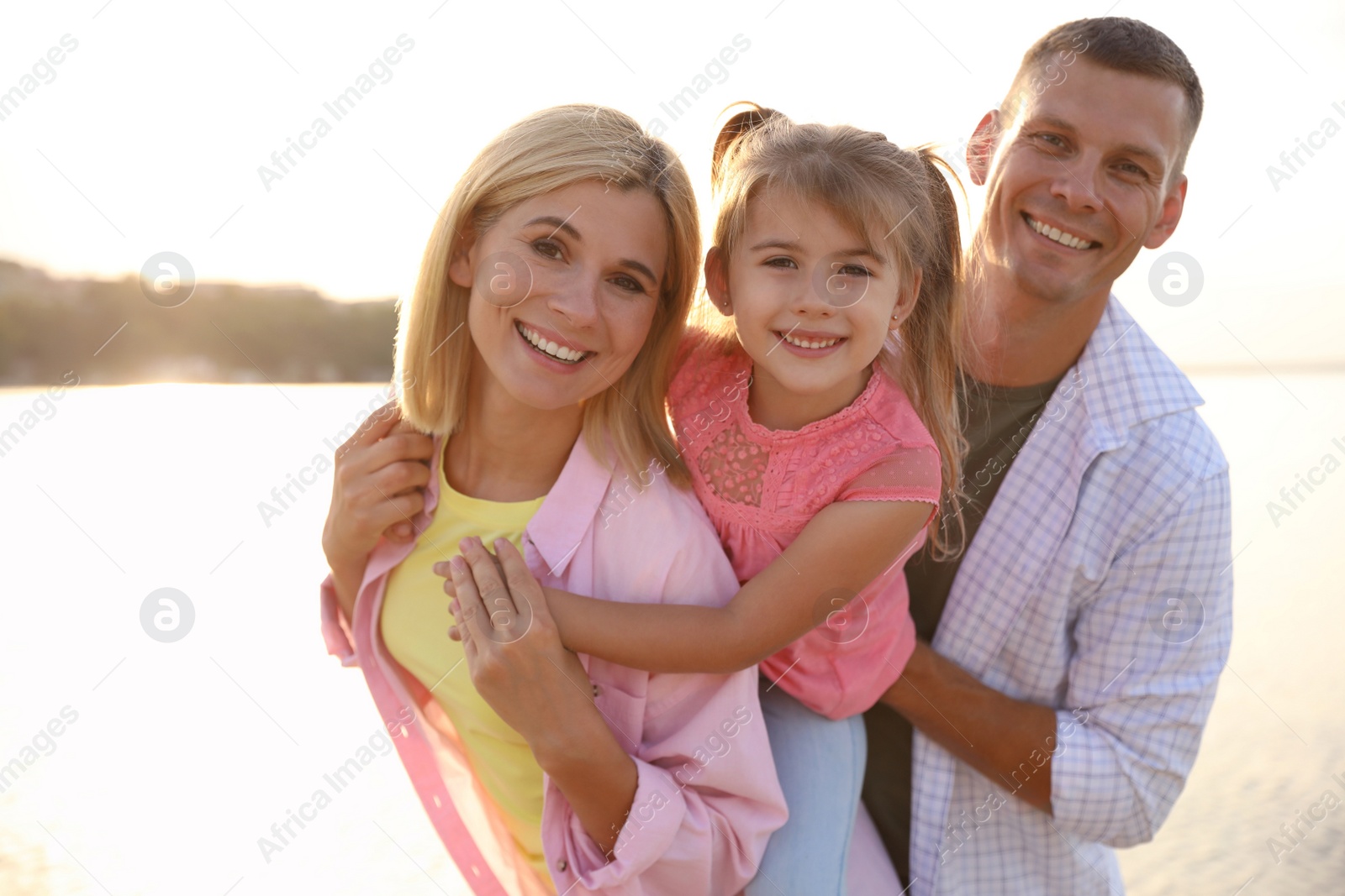 Photo of Happy parents with their child on beach. Spending time in nature