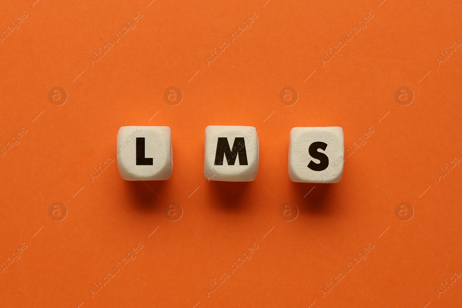 Image of Learning management system. Wooden cubes with abbreviation LMS on orange background, top view