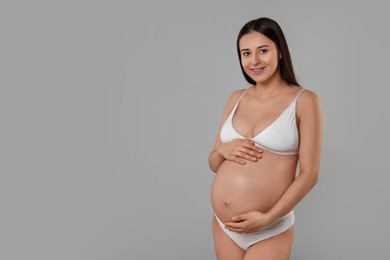 Beautiful pregnant woman in stylish comfortable underwear on grey background, space for text