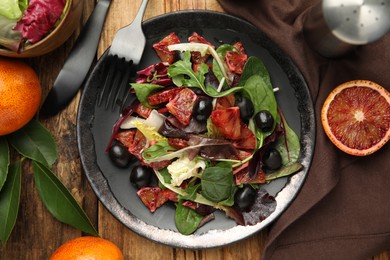 Photo of Delicious salad with sicilian orange served on wooden table, flat lay