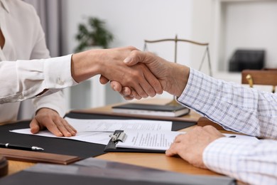 Photo of Lawyer shaking hands with client in office, closeup