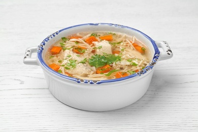 Photo of Dish with fresh homemade chicken soup on wooden background