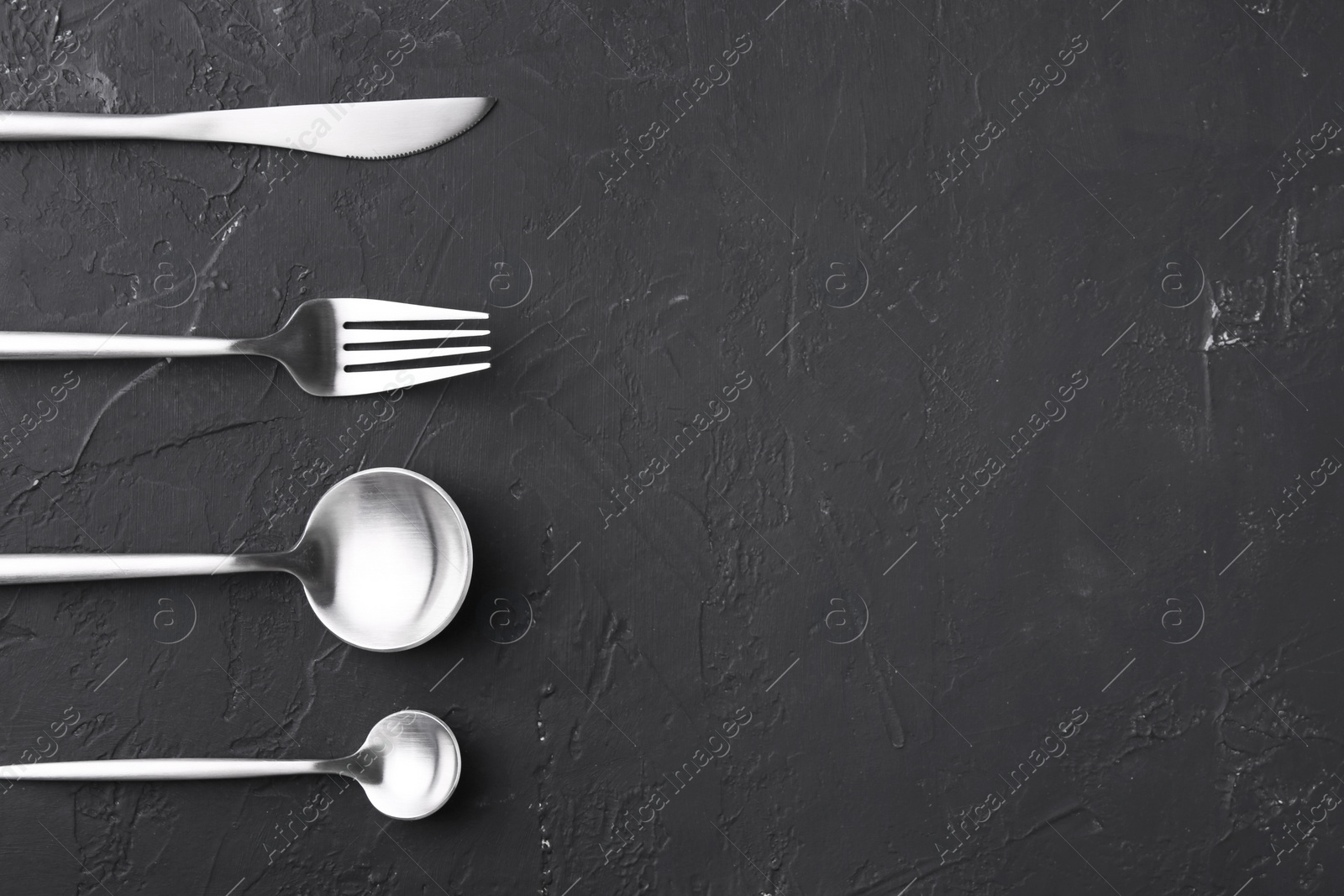 Photo of Beautiful cutlery set on black table, flat lay. Space for text