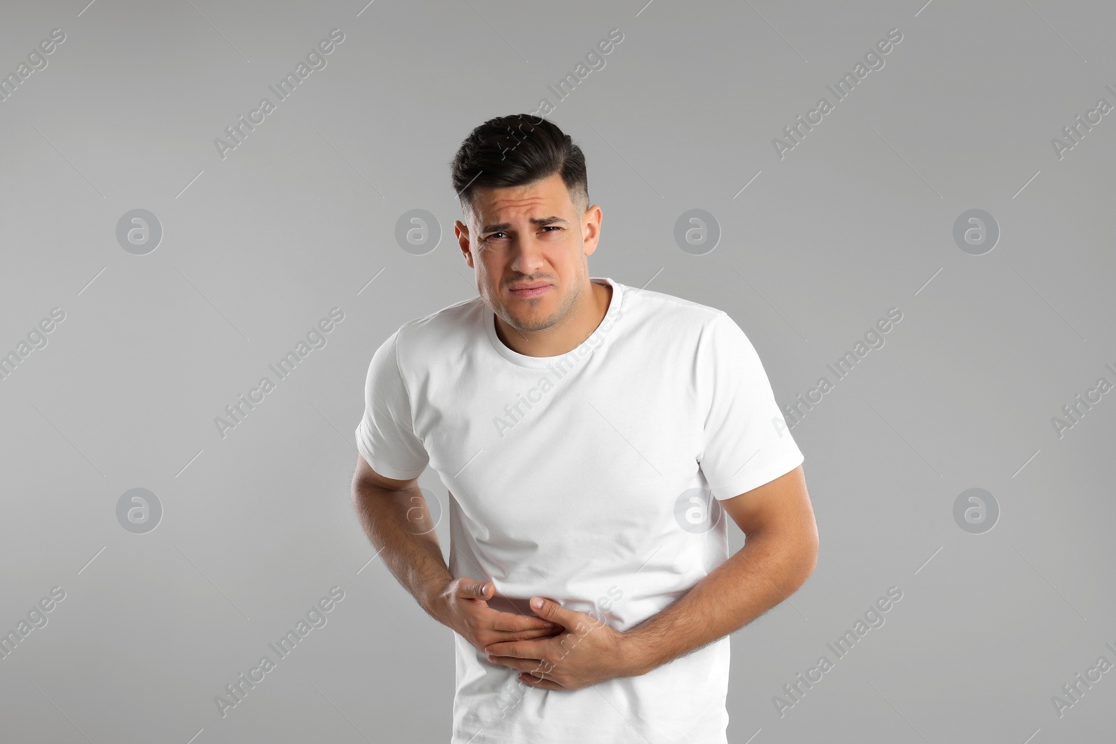 Photo of Man suffering from liver pain on grey background