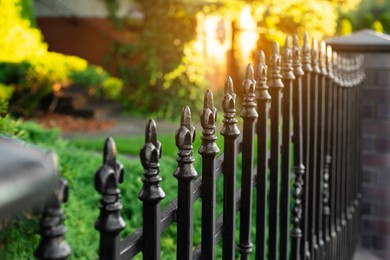 Photo of Railing of beautiful black iron fence outdoors, closeup