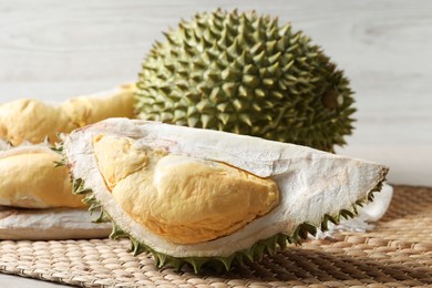 Photo of Fresh ripe durian fruits on wicker mat
