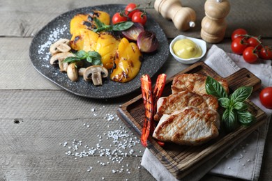 Delicious grilled meat and vegetables served on wooden table