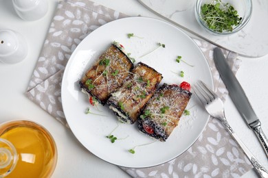 Photo of Delicious baked eggplant rolls served on white table, flat lay