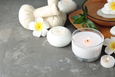 Photo of Beautiful spa composition with candles and flowers on grey background, space for text