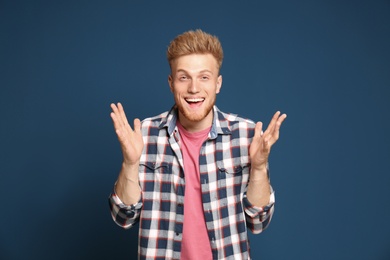 Portrait of happy young man on blue background