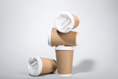 Photo of Paper cups with white lids on light gray background. Coffee to go