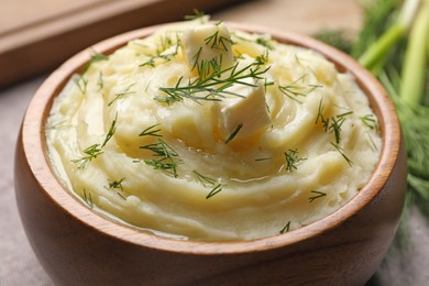 Photo of Bowl of delicious mashed potato with dill and butter, closeup