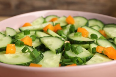 Photo of Tasty fresh salad with cucumber in bowl, closeup