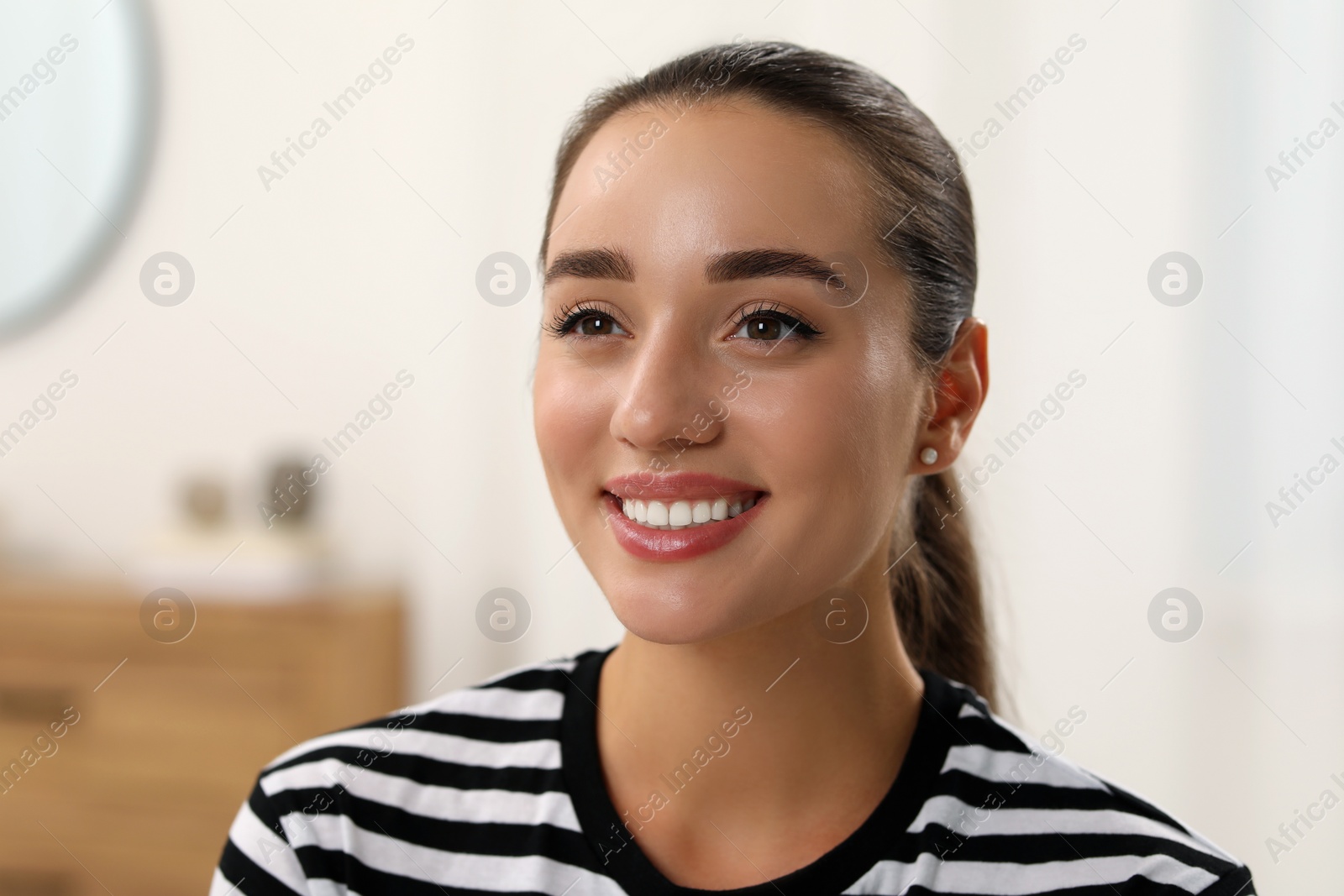 Photo of Portrait of beautiful young woman indoors. Attractive lady posing for camera