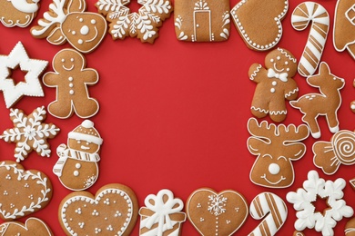 Photo of Frame made with different Christmas gingerbread cookies on red background, flat lay. Space for text