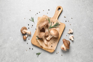 Flat lay composition with fresh wild mushrooms on light grey table