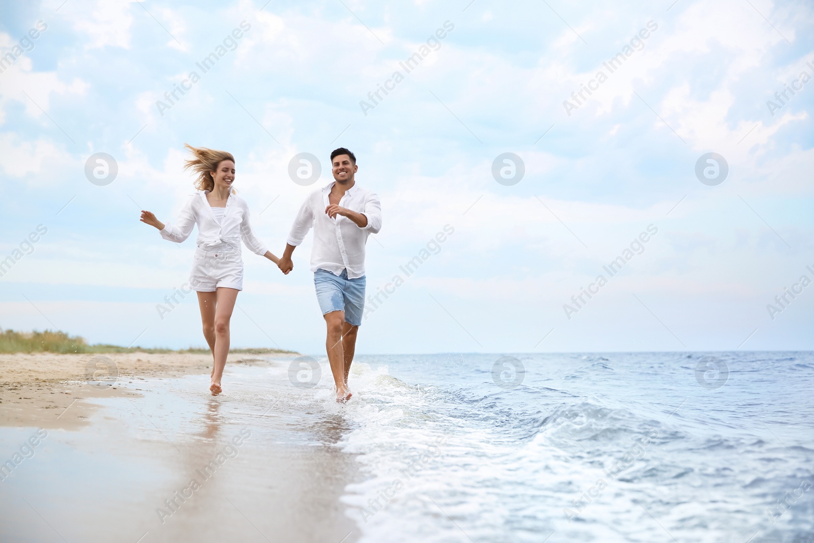 Photo of Happy couple running on beach, space for text. Romantic walk