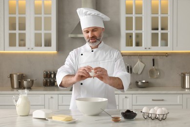Professional chef making dough at white marble table in kitchen