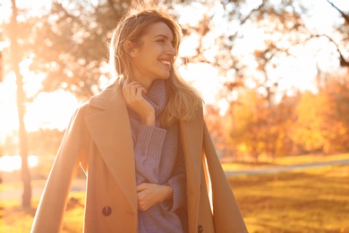 Photo of Beautiful young woman wearing stylish clothes in autumn park