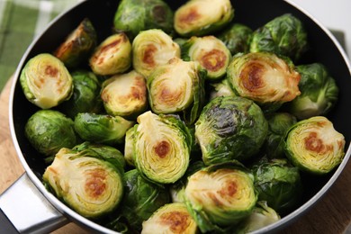Photo of Delicious roasted Brussels sprouts in frying pan on table, closeup