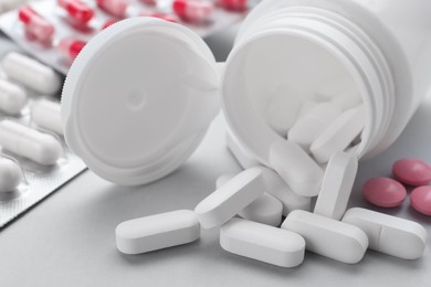 Photo of Different antidepressants and medical bottle on grey background, closeup