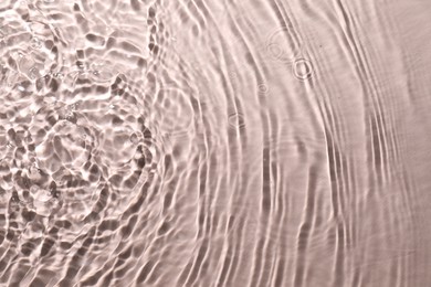 Photo of Rippled surface of clear water on beige background, top view