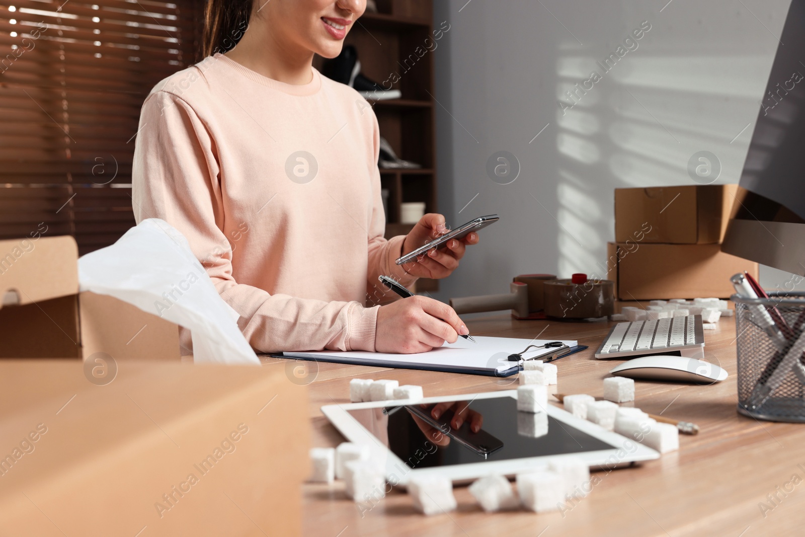 Photo of Seller working at table in office, closeup. Online store