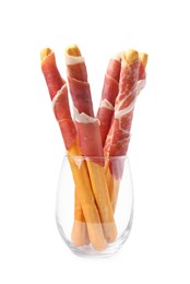 Tasty grissini sticks with prosciutto in glass isolated on white