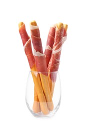 Photo of Tasty grissini sticks with prosciutto in glass isolated on white