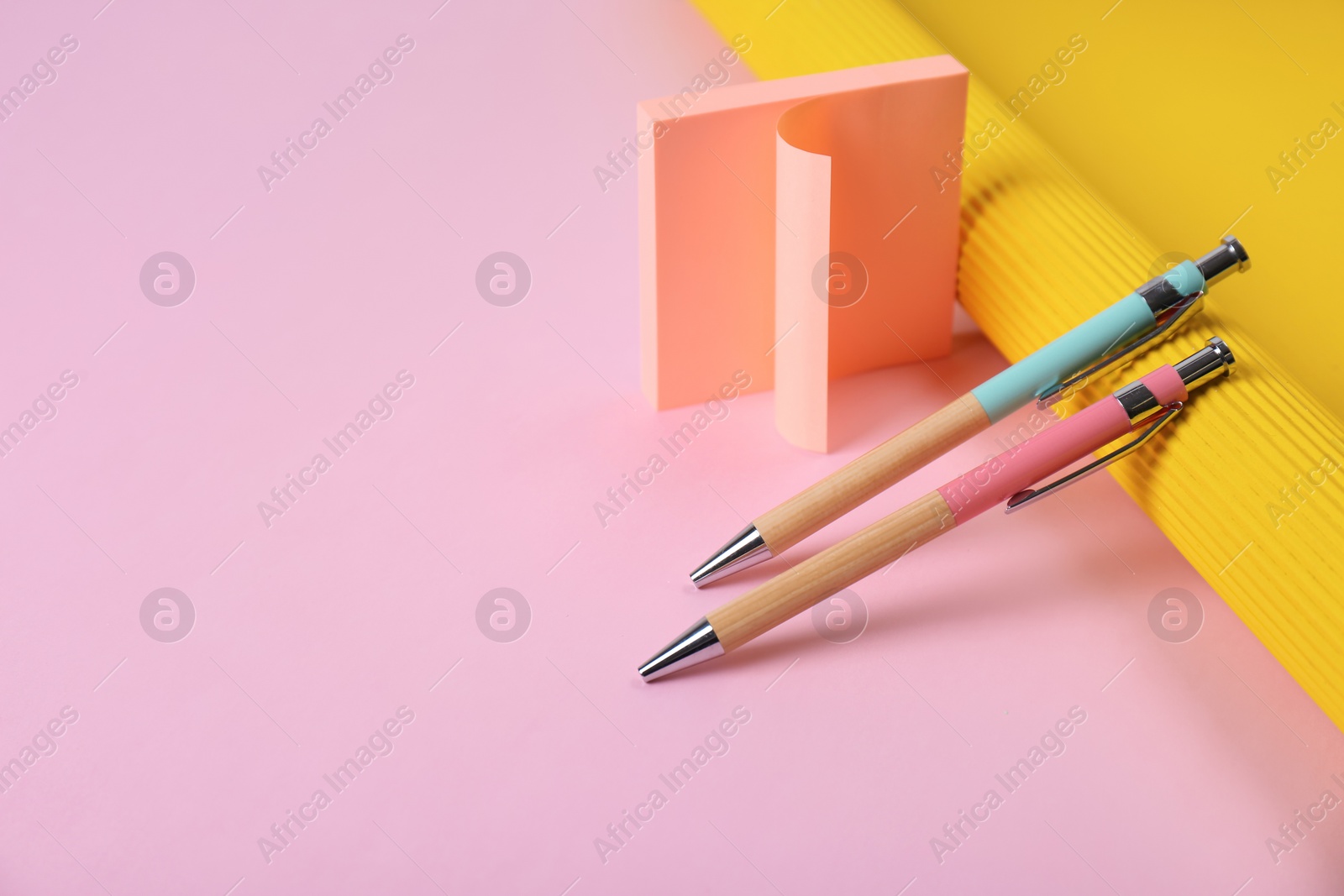 Photo of Composition with pens and sticky notes on color background. Space for text