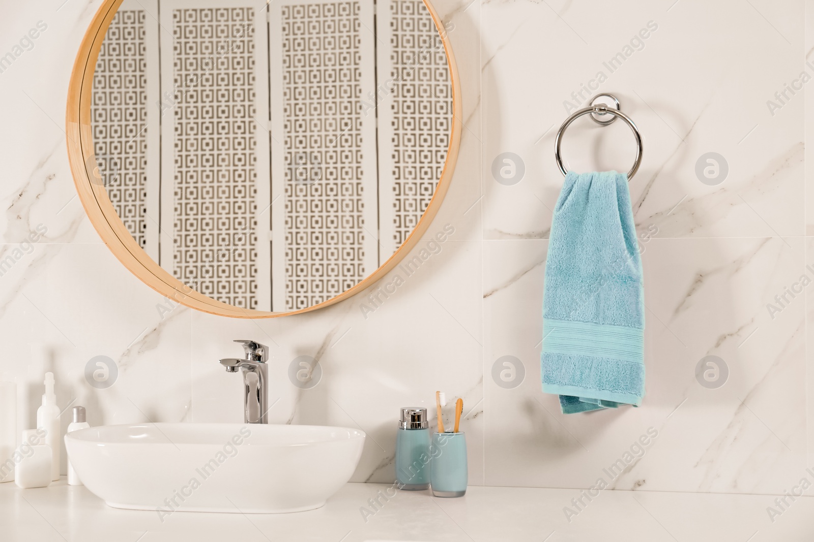 Photo of Bathroom interior with mirror, countertop and soft towel on wall
