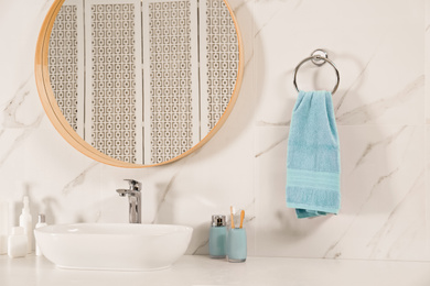 Photo of Bathroom interior with mirror, countertop and soft towel on wall