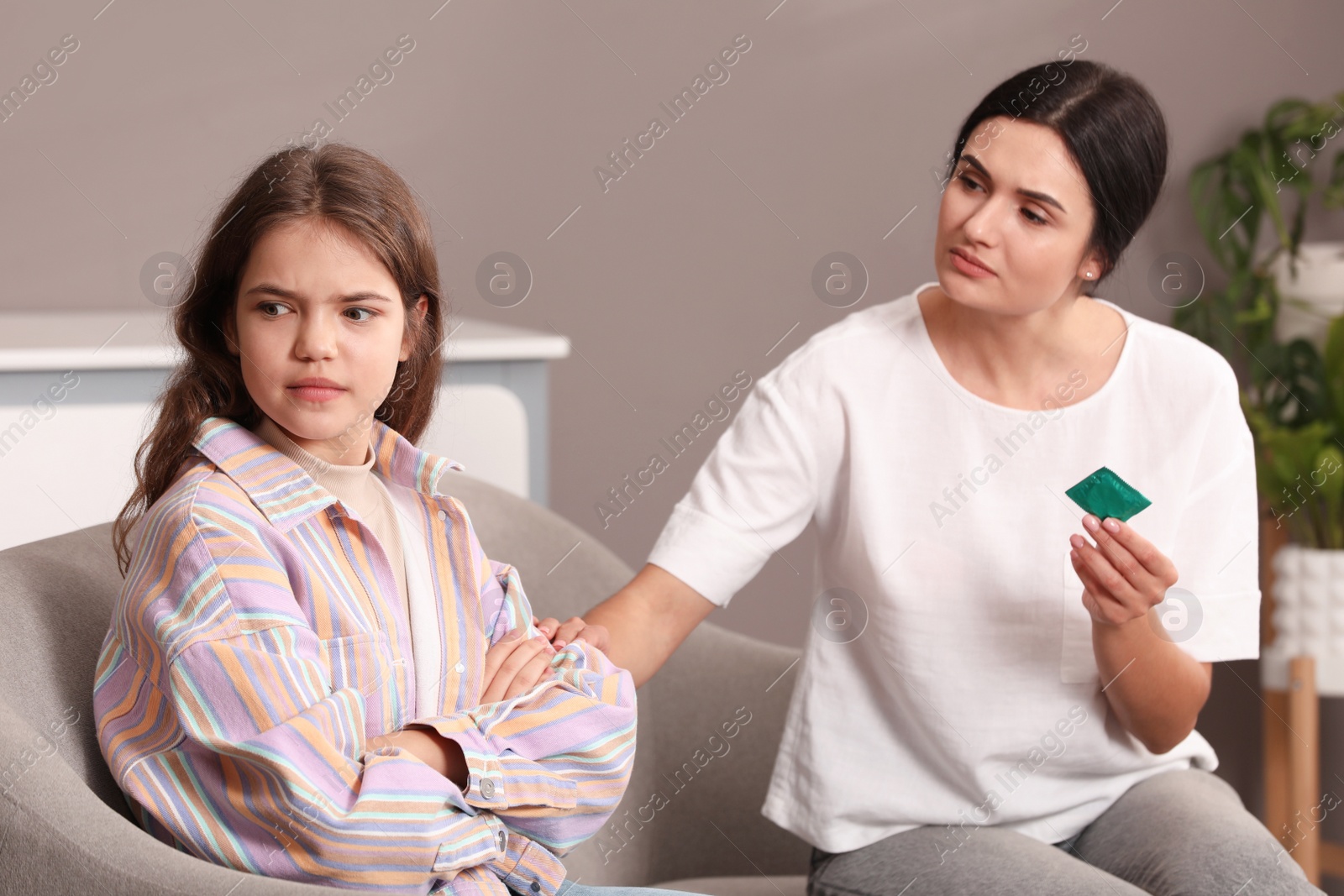 Photo of Mother talking with her teenage daughter about contraception at home. Sex education concept